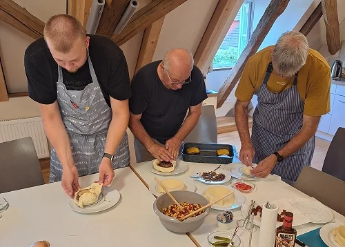 Mitglieder des Männerkochklubs bereiten gemeinsam ein Essen vor